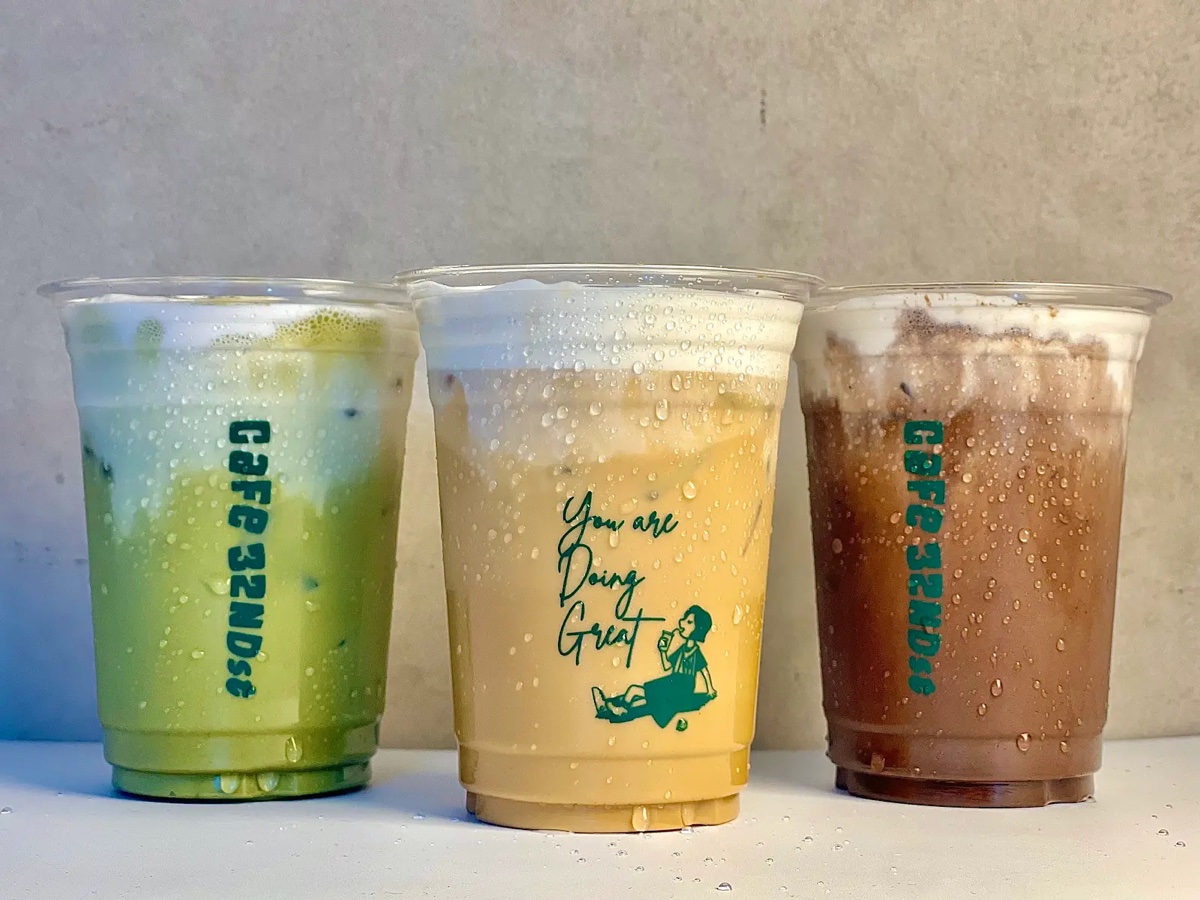 Three iced drinks in Cafe 32nd St branded cups — matcha, latte, and mocha