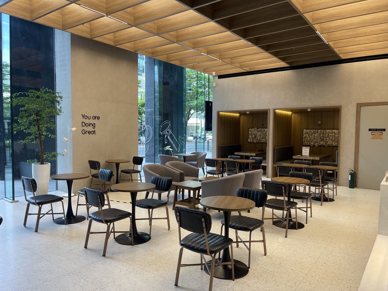 Cafe 32nd St lounge seating area with 'You are Doing Great' wall art and private booth alcoves